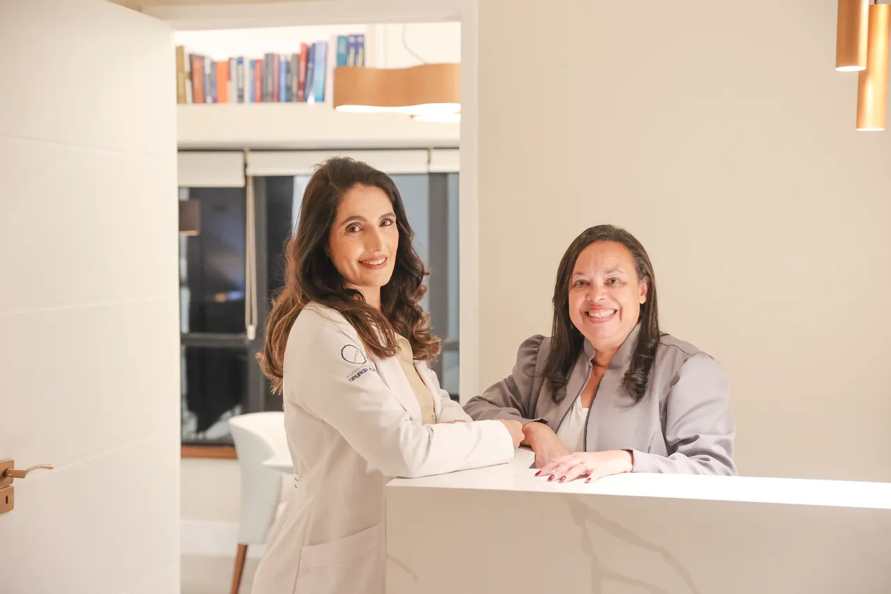 Dra. Vanessa Rajo ao lado de uma mulher na recepção da clínica